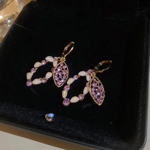 Detailed macro view of vintage oval pendants with pink rhinestones and gold plating