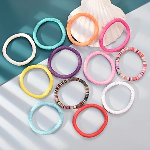 Flat lay of colorful 6mm clay bead friendship bracelets arranged with a seashell