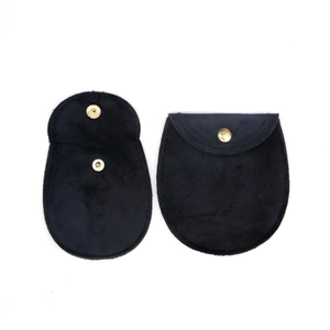 Detail showing open and closed black velvet jewelry pouches with golden snap button fastens