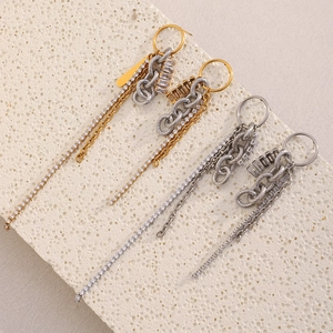 Detail showing gold and silver tassel earrings with zircons on a natural stone base