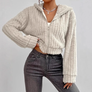 Detail of white cropped zip-up hoodie showing vertical ribbed faux fur texture and metal zipper