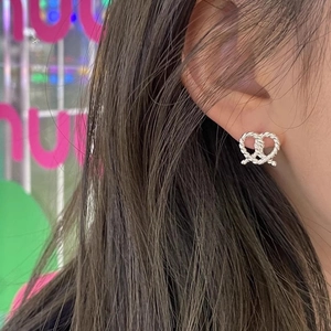 Elegant s925 silver twisted heart knot stud earrings worn by a model in soft lighting