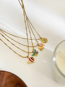 Close-up of colorful enamel animal pendants on gold stainless steel necklaces