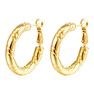 Macro detail of gold-plated twisted texture on stainless steel hoop earrings