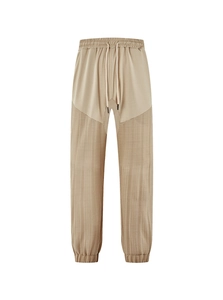 Detail of khaki drawstring linen pants showing spliced fabric and ribbed cuff design