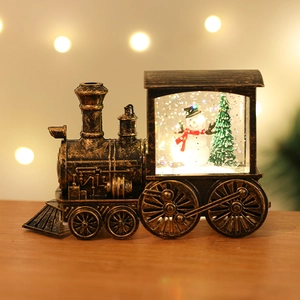 Macro shot of vintage bronze train snow globe with snowman and warm LED lighting effect
