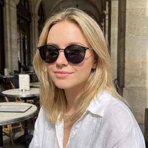 Chic retro round polarized sunglasses with black frames worn by model in street scene