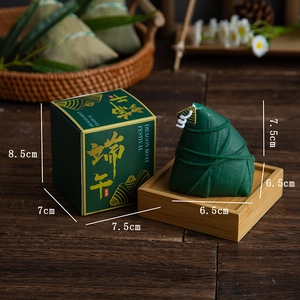 Detail of green zongzi-shaped scented candle in a gold-foiled Dragon Boat gift box