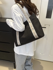 Dettaglio borsa tote nera con tracolla a motivi etnici geometrici e design casual moderno