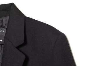 Detailed view of the textured black blazer shoulder and collar with fine fabric weave