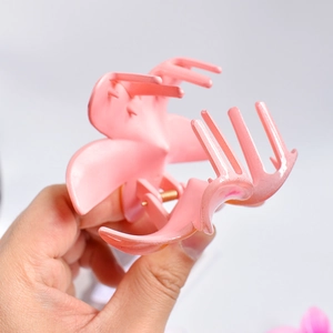 Detailed close-up of a pink matte flower hair claw clip with a strong metal spring mechanism