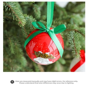 Close-up of red Christmas bauble with car illustration and green bow on tree