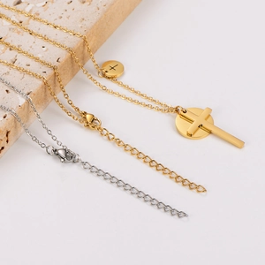 Detail of round pendant necklaces with 3D cross in gold and silver stainless steel finishes