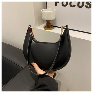 Detail of black crescent moon bag with smooth PU leather finish and gold zipper hardware