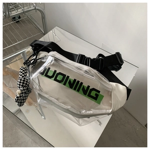 Détail du sac bandoulière en PVC transparent avec coutures blanches et breloque lapin à damier