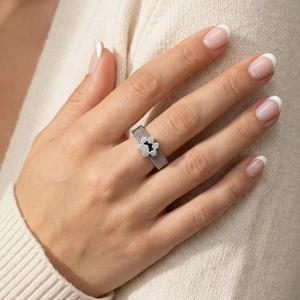 Minimalist stainless steel mesh ring with black enamel cat paw charm on model hand