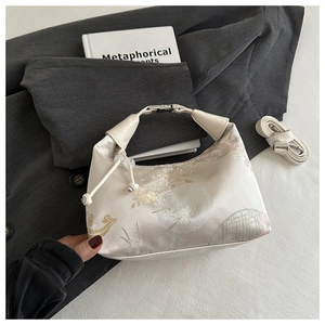 Detail of cream Chinese style handbag with floral embroidery and pearl drawstring closure