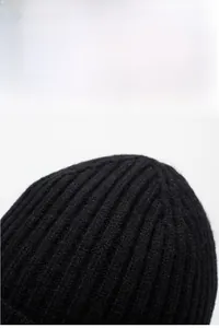 Dettaglio della spessa trama a coste di questo caldo berretto nero in maglia da uomo