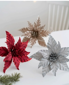 Close-up of glittered poinsettia flowers in red, silver, and champagne for decor