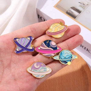 Detailed close-up of colorful enamel space planet pins with gold plating details