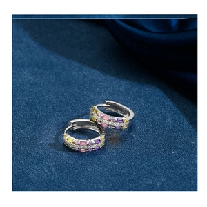 Close-up of S925 silver hoop earrings with multicolored cubic zirconia on navy silk