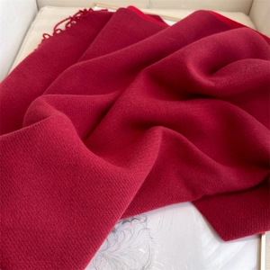 Detailed close-up of dark red cashmere-like scarf showing soft texture and fringe edges