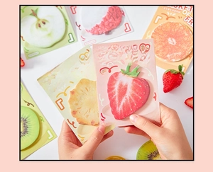 Close-up of realistic fruit-shaped sticky notes showing strawberry and kiwi designs
