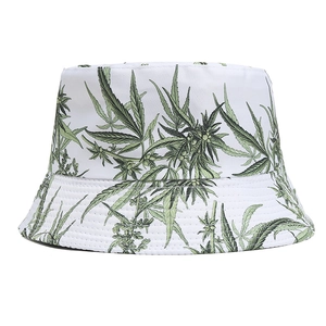 Détail d'un chapeau bob blanc avec imprimé feuilles vertes et coutures parallèles précises