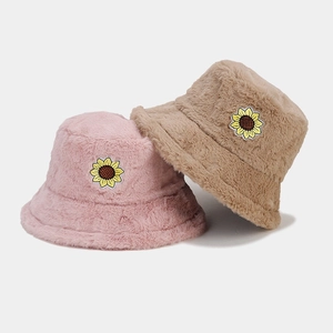 Winter plush bucket hats in pink and khaki with sunflower embroidery on white background