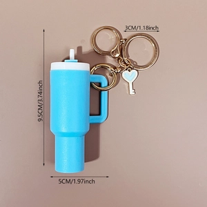 Blue cup keychain with heart charm and gold ring, product dimensions shown on beige backdrop