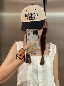 Detail of LOVER and heart embroidery on a beige and black contrast baseball cap