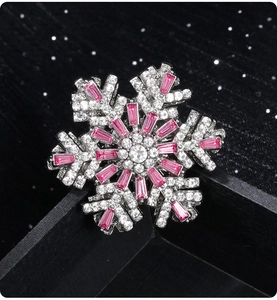 Macro shot of a 3D snowflake brooch with pink cubic zirconia and silver plating