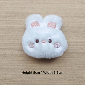 Macro detail of white plush bunny accessory with pink embroidery 5cm x 5.5cm