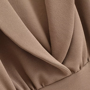 Detail of dark brown textured fabric and crossover V-neckline of the sleeveless two-piece set