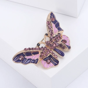 Macro shot of purple and pink enamel butterfly brooch with inlaid purple crystals on gold alloy
