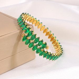 Detail of a gold-plated titanium bracelet featuring green marquise-cut zircon stones