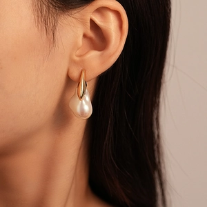 Gros plan détaillé de boucles d'oreilles en perles baroques avec crochets dorés