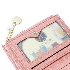 Detail of pink faux leather card holder featuring a metal pearl pendant and clear ID window