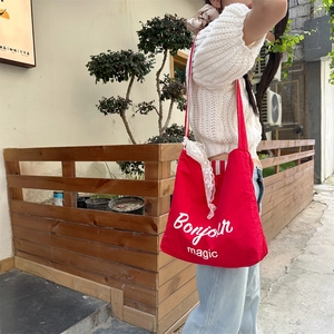 Detail of red canvas tote bag with white lace trim and Bonjour magic print