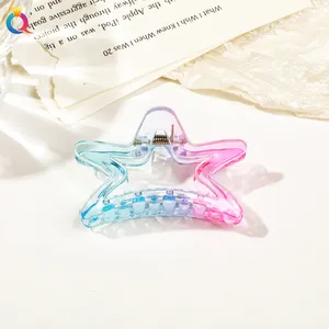 Detail of star-shaped hair claw clip with blue and pink gradient on book background