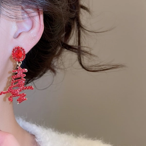 Detail of red Chinese Xi character tassel earrings with gold plating on model