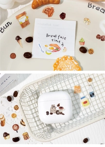 Detail showing vintage food stickers on earbuds case and breakfast themed stationery