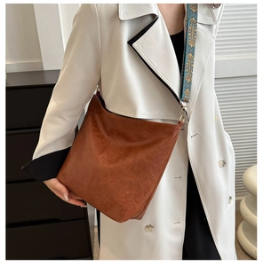Close-up of brown PU leather tote bag with colorful ethnic embroidered wide strap