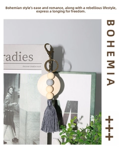 Detail of Bohemian keychain with wooden beads, grey tassel, and vintage metal hook