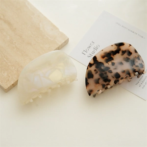 Detail of high-end acetate hair claws in cream marble and dark tortoiseshell patterns