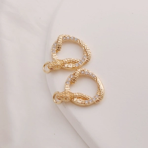 Macro shot of 14K gold-plated snake charms with sparkling zircon pavé for jewelry DIY