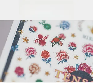 Close-up of vibrant flower nail art stickers featuring red roses and sunflowers
