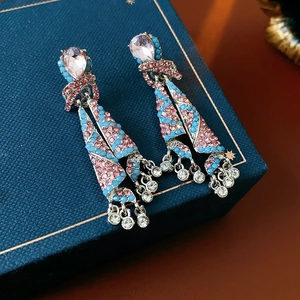 Vue macro de boucles d'oreilles vintage avec strass roses et perles bleu ciel