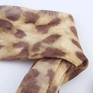 Close-up of leopard print sheer mesh fabric showing intricate texture and soft draping