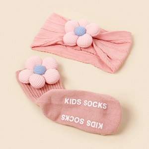 Détail du bandeau bébé et chaussettes antidérapantes roses avec fleur 3D et tricot
